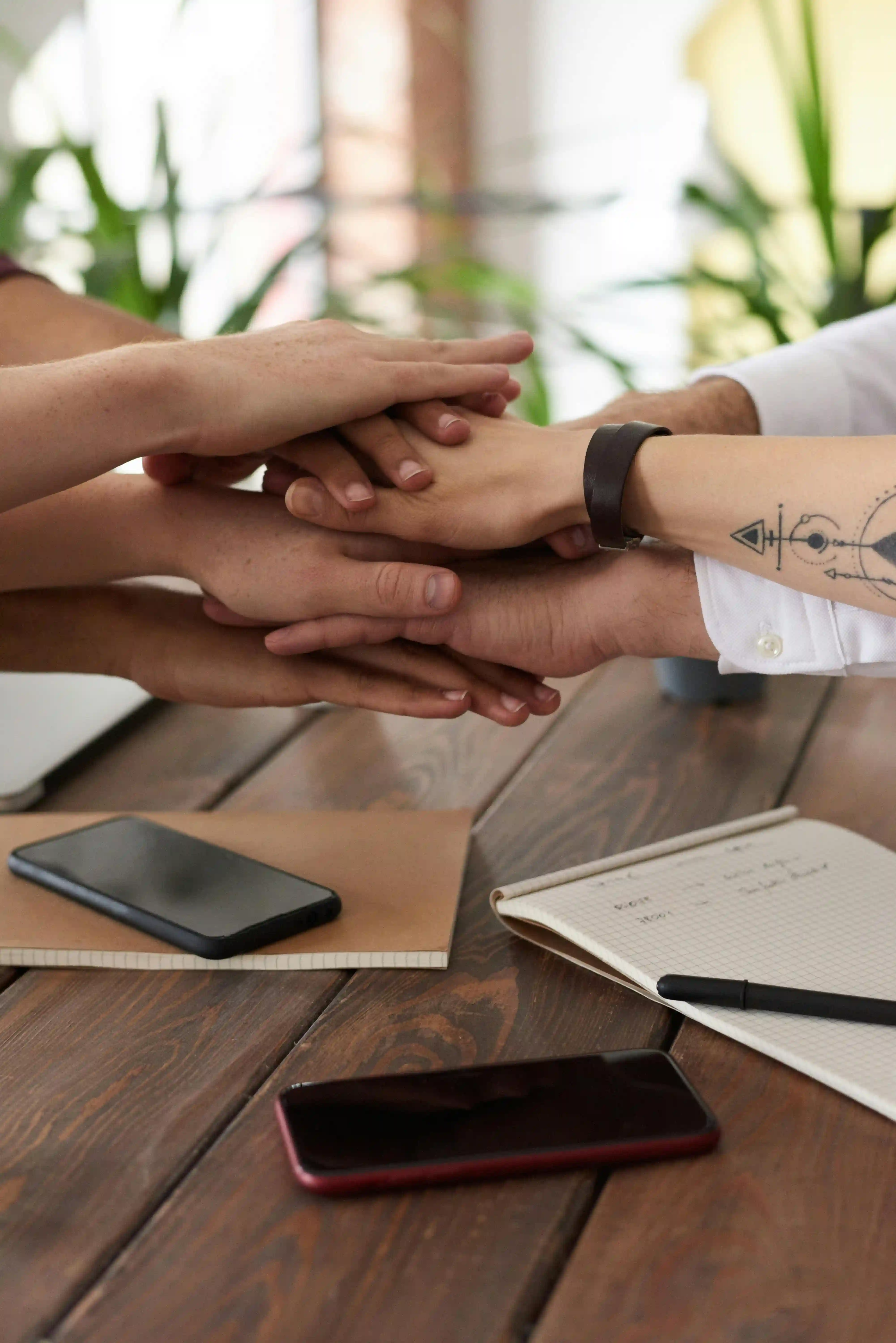 Personas uniendo manos en señal de equipo y ayuda